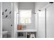 Bright mudroom features a storage bench, white paneled walls, and a view to the toilet at 5252 N College Ave, Indianapolis, IN 46220