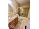 Bathroom with tiled floors, an oak vanity, a gold-framed mirror, and a glass-enclosed shower at 5329 Hawks Point Rd, Indianapolis, IN 46226