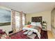 Bedroom with hardwood floor, large windows, floral curtains, and unique headboard at 5333 Thicket Hill Ln, Indianapolis, IN 46226
