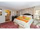 Bright bedroom featuring a large bed, colorful floral curtains, and a red oriental rug at 5333 Thicket Hill Ln, Indianapolis, IN 46226
