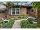 Inviting brick home entrance, featuring a stone bench and walkway surrounded by lush landscaping at 5333 Thicket Hill Ln, Indianapolis, IN 46226