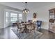 Bright dining room featuring a bay window, hardwood floors, an elegant chandelier, and comfortable seating at 5524 Coventry Park Way, Indianapolis, IN 46237