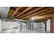 Unfinished basement with laundry machines, water heater, and exposed beams at 5945 Mcfarland Rd, Indianapolis, IN 46227