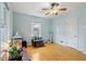 Bright bedroom featuring hardwood floors, a ceiling fan, and a window with natural light at 5945 Mcfarland Rd, Indianapolis, IN 46227