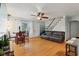 Bright living room featuring hardwood floors, a ceiling fan, and easy access to the staircase at 5945 Mcfarland Rd, Indianapolis, IN 46227