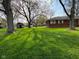 Large backyard features a storage shed and plenty of green space for outdoor activities and relaxation at 7002 Mclain Dr, Indianapolis, IN 46217