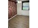 Bedroom showcasing wood-look floors, painted accent wall, and natural light at 7002 Mclain Dr, Indianapolis, IN 46217