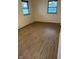 Bright bedroom features wood-look floors and two windows providing ample natural light at 7002 Mclain Dr, Indianapolis, IN 46217