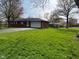 Well-maintained single-story brick home with a green lawn and attached garage, offering suburban living at 7002 Mclain Dr, Indianapolis, IN 46217