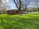 Single-story brick home on a verdant lot, showcasing its exterior and landscaping at 7002 Mclain Dr, Indianapolis, IN 46217