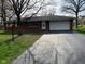 Charming single-story brick home featuring an attached garage and a long driveway at 7002 Mclain Dr, Indianapolis, IN 46217