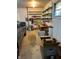This cluttered garage contains shelving, a ladder, a workbench, storage bins, and a parked car at 7002 Mclain Dr, Indianapolis, IN 46217