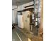 A utility garage space with shelving, an HVAC unit, a hot water tank, and an old safe at 7002 Mclain Dr, Indianapolis, IN 46217