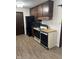 This kitchen features dark wood cabinets and a mix of black and white appliances set on wood-look floors at 7002 Mclain Dr, Indianapolis, IN 46217