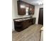 A functional kitchen is complete with dark wood cabinets, a window, and wood-look vinyl flooring at 7002 Mclain Dr, Indianapolis, IN 46217