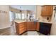 Functional kitchen with wood cabinetry, a view to a seating area, and modern black appliances at 716 Bristol Ct, Greenwood, IN 46143
