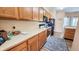 Kitchen with warm wood cabinets, a black refrigerator, and view into a breakfast nook with lots of light at 716 Bristol Ct, Greenwood, IN 46143