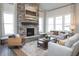 Elegant living room featuring a stone fireplace, hardwood floors, comfortable seating, and natural light at 7282 Portico Ln, McCordsville, IN 46055