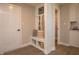 Well-organized mudroom features built-in bench, coat hooks, decorative pillows, and easy access to storage at 7282 Portico Ln, McCordsville, IN 46055