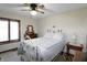 Bright bedroom with a white bed frame, ceiling fan, dresser, and a window at 7608 Andrew Turn, Plainfield, IN 46168