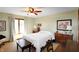 Bright bedroom featuring a white iron bed frame, ceiling fan and a large window at 7608 Andrew Turn, Plainfield, IN 46168