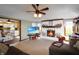 Cozy living room featuring a brick fireplace, neutral carpet, and ceiling fan with views into the kitchen at 7608 Andrew Turn, Plainfield, IN 46168