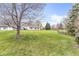 Spacious backyard with lush green grass and mature trees surrounding the perimeter at 7715 High View Cir, Indianapolis, IN 46236
