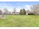 Expansive backyard featuring lush green grass, mature trees, and a white storage shed at 7715 High View Cir, Indianapolis, IN 46236