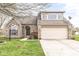 Charming brick home featuring a well-maintained lawn, arched entry, and attached two-car garage at 7715 High View Cir, Indianapolis, IN 46236
