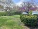 Expansive backyard with flowering trees, mature hedges, and outbuildings at 7740 5 Points Rd, Indianapolis, IN 46259