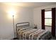 Cozy bedroom with a patterned quilt on the bed and a window with red curtains at 7740 5 Points Rd, Indianapolis, IN 46259