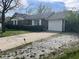 Cozy brick home with white garage door, manicured shrubbery, and inviting curb appeal at 7740 5 Points Rd, Indianapolis, IN 46259