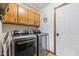Well-lit laundry room features stainless steel washer and dryer and wooden storage cabinets at 8095 Christopher Ct, Avon, IN 46123