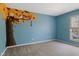 Bedroom with a blue accent wall featuring Calvin and Hobbes mural, neutral carpet and good natural light at 8235 Picadilly Ln, Indianapolis, IN 46256