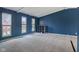 Open bonus room with blue walls, plush carpeting, and plenty of natural light at 8235 Picadilly Ln, Indianapolis, IN 46256