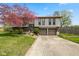 Charming two-story home featuring a well-maintained lawn, mature tree, and an attached two-car garage at 8235 Picadilly Ln, Indianapolis, IN 46256