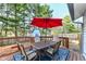 Back deck with outdoor dining set and red umbrella; ideal for entertaining and enjoying the outdoors at 8506 Friendship Ln, Indianapolis, IN 46217