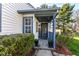 Inviting front porch with a decorative welcome sign, a blue mat and potted plants at 8506 Friendship Ln, Indianapolis, IN 46217