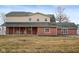 A charming two-story home features a brick facade, covered porch, and rocking chairs at 8543 W County Road 600 S, Coatesville, IN 46121