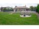 Manicured backyard featuring a tennis court and lounge area with a fire pit, ideal for recreation and relaxation at 8737 Chateaugay Dr, Indianapolis, IN 46217