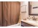 Bathroom with a shower/tub combo, granite countertop, dark cabinets, and dark fixtures at 8737 Chateaugay Dr, Indianapolis, IN 46217