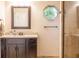 Stylish bathroom with a granite countertop, wood cabinets, unique octagonal window, and tiled shower at 8737 Chateaugay Dr, Indianapolis, IN 46217