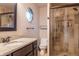 Bathroom featuring granite countertop, wood cabinets, octagonal window, toilet, and glass shower at 8737 Chateaugay Dr, Indianapolis, IN 46217