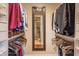 Walk-in closet with built-in shelving, hanging clothes, and a mirror with a bathroom reflection at 8737 Chateaugay Dr, Indianapolis, IN 46217