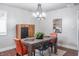 Bright dining room featuring a modern chandelier, hardwood floors, and colorful chairs, ideal for gatherings at 8737 Chateaugay Dr, Indianapolis, IN 46217