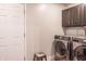 Laundry room features washer, dryer, utility cabinet, and a door at 8737 Chateaugay Dr, Indianapolis, IN 46217