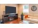 Comfortable living room featuring a sleek entertainment center, hardwood floors, and ample natural light at 8737 Chateaugay Dr, Indianapolis, IN 46217