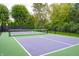 Aerial view of the full tennis court enclosed with a black fence and mature landscaping at 8737 Chateaugay Dr, Indianapolis, IN 46217
