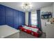 Fun, themed bedroom with stylish blue accent wall, modern light fixture, and whimsical car bed at 10047 Perlita Pl, Fishers, IN 46038