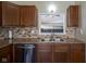Kitchen sink with stainless steel dishwasher, stylish backsplash and wood cabinets at 10047 Perlita Pl, Fishers, IN 46038